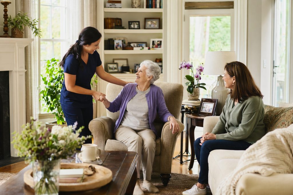caregiver warmly assisting an elderly adult